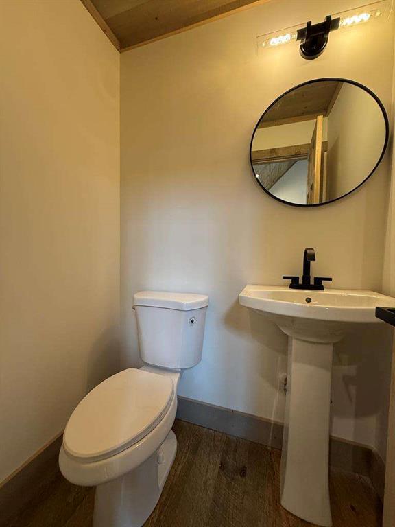 bathroom with toilet and hardwood / wood-style floors