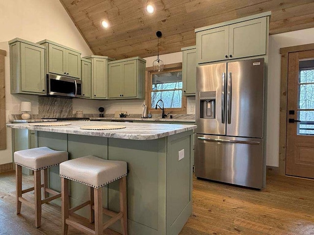 kitchen featuring appliances with stainless steel finishes, a breakfast bar, green cabinets, wood ceiling, and light hardwood / wood-style flooring