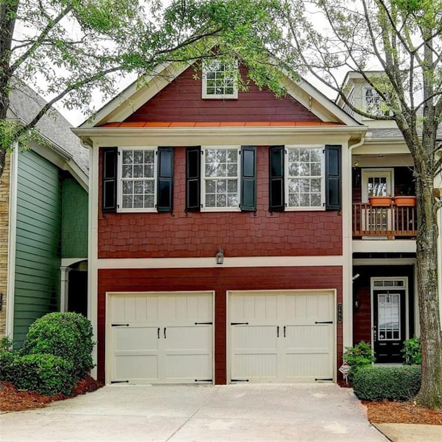 view of front of home with a garage, concrete driveway, and a balcony
