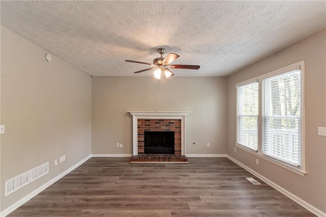 unfurnished living room featuring wood finished floors, visible vents, a textured ceiling, and ceiling fan