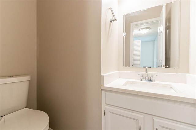 half bathroom with toilet and vanity