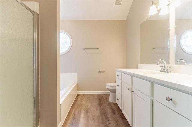 full bath featuring wood finished floors, visible vents, toilet, vanity, and a bath