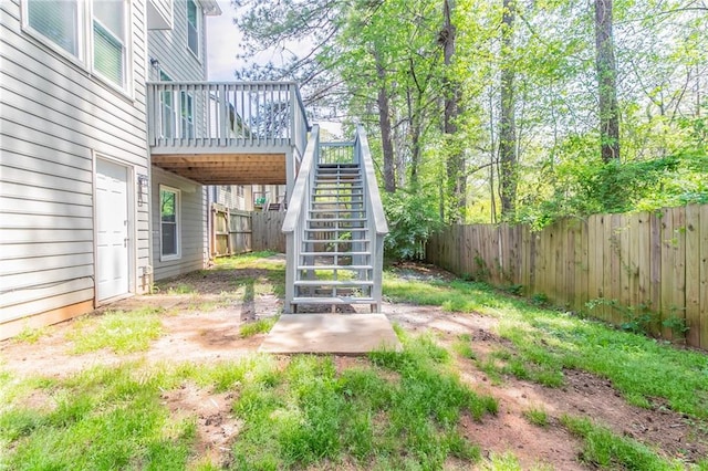 view of yard featuring stairway, a fenced backyard, and a deck