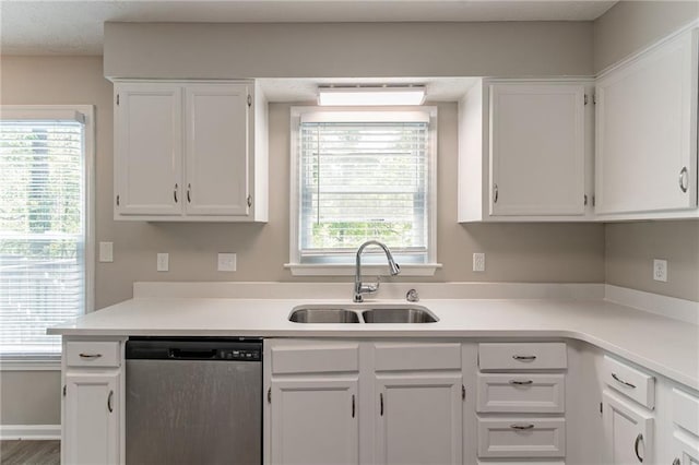 kitchen featuring white cabinets, stainless steel dishwasher, light countertops, and a sink