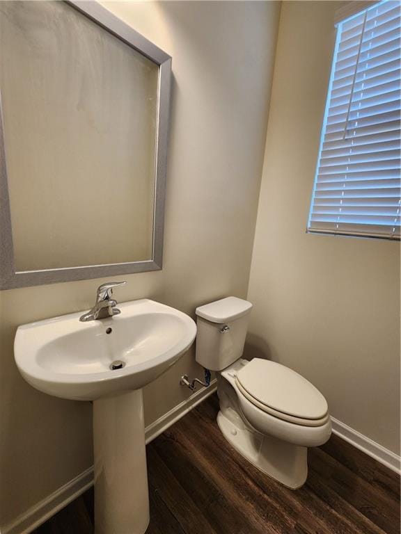 bathroom with hardwood / wood-style floors and toilet