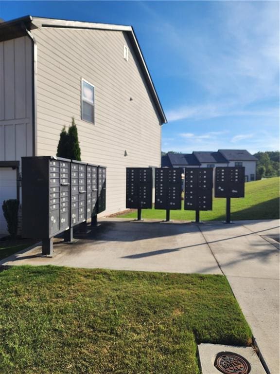 view of property's community with a lawn and a mail area