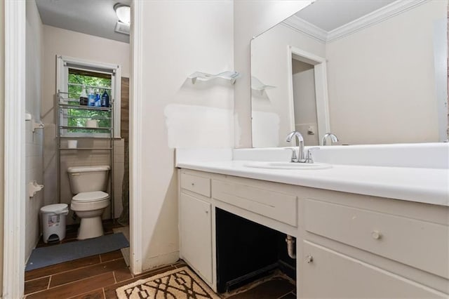 bathroom featuring vanity, toilet, crown molding, and wood-type flooring