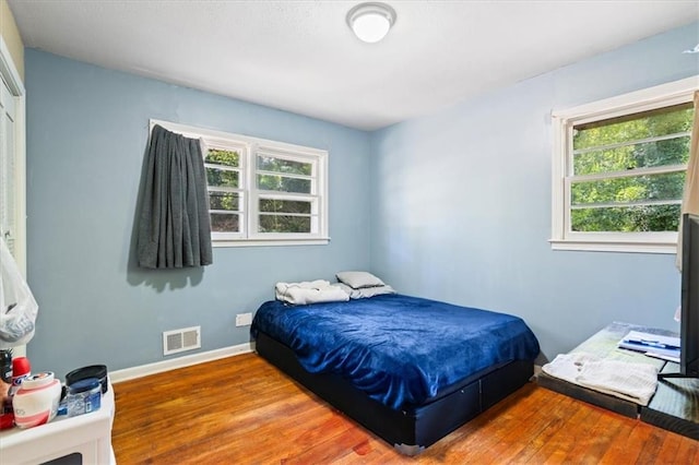 bedroom featuring multiple windows and hardwood / wood-style flooring