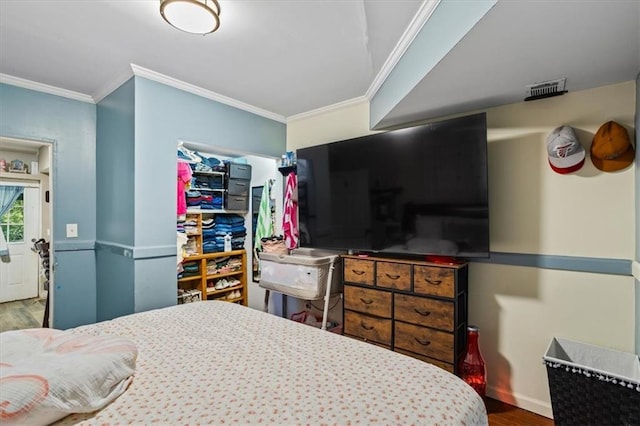 bedroom with ornamental molding and hardwood / wood-style flooring