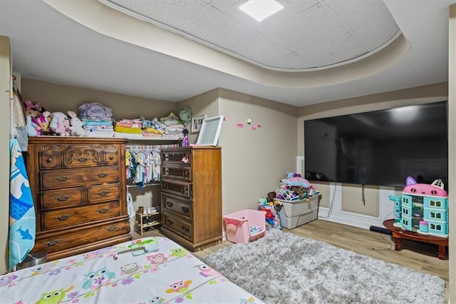 bedroom featuring hardwood / wood-style flooring and a tray ceiling