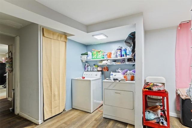 clothes washing area with separate washer and dryer and light wood-type flooring