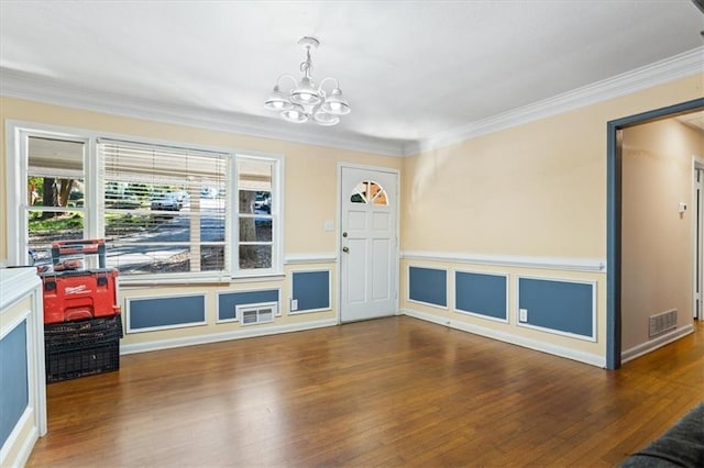 interior space with wood-type flooring, ornamental molding, and a chandelier