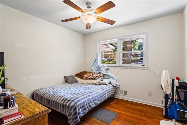 bedroom with dark hardwood / wood-style flooring and ceiling fan