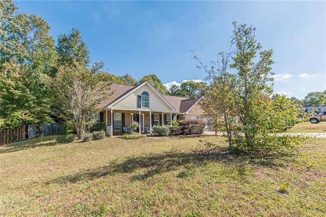 view of front of property with a porch, a front yard, and a garage