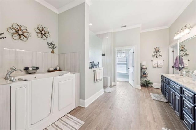 270 Morrow Rd, Newborn, GA 30056 - bathroom with crown molding, wood finished floors, washer / dryer, a bath, and vanity