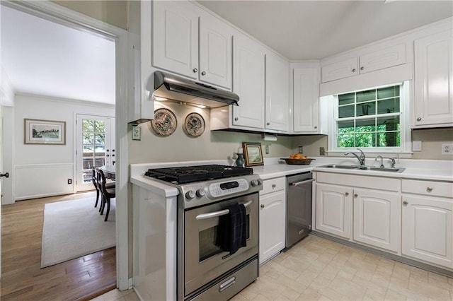 kitchen featuring appliances with stainless steel finishes, a sink, light countertops, under cabinet range hood, and white cabinetry