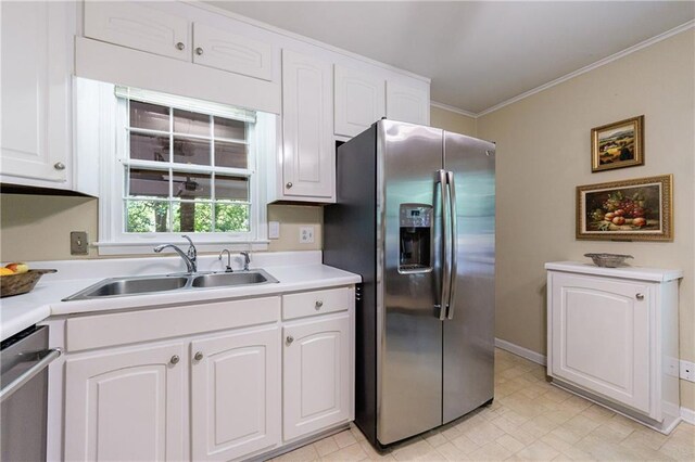 kitchen with white cabinets, crown molding, a sink, light countertops, and stainless steel appliances