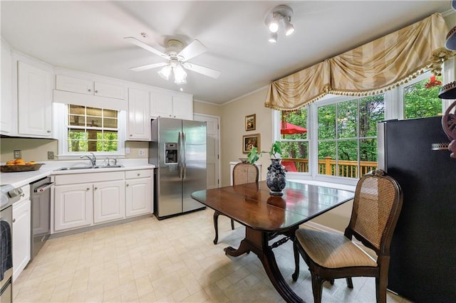kitchen with a sink, white cabinetry, appliances with stainless steel finishes, and light countertops