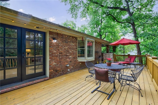 wooden deck featuring french doors and outdoor dining space