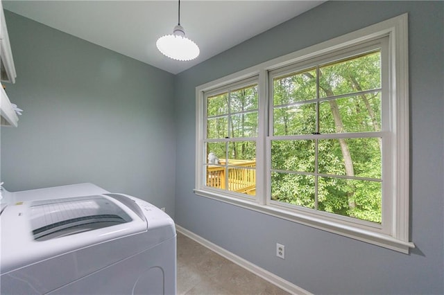 laundry area with light tile patterned floors, baseboards, laundry area, and washer / clothes dryer