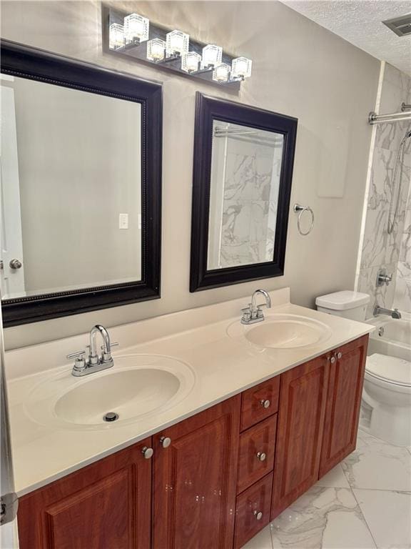 121 Brittany Ct, Duluth, GA 30096 - full bathroom with double vanity, a textured ceiling, marble look tiles, toilet, and shower / washtub combination