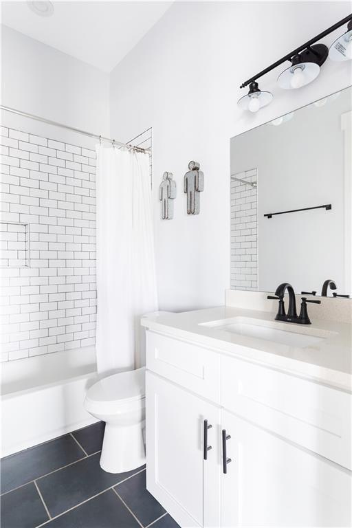 bathroom with tile patterned floors, toilet, vanity, and shower / tub combo with curtain