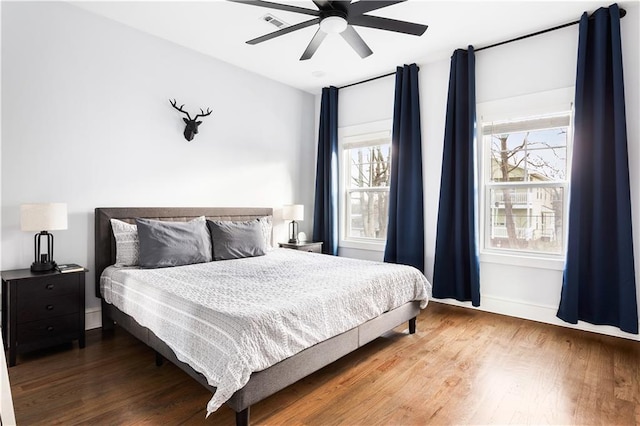 bedroom featuring wood finished floors, baseboards, and a ceiling fan