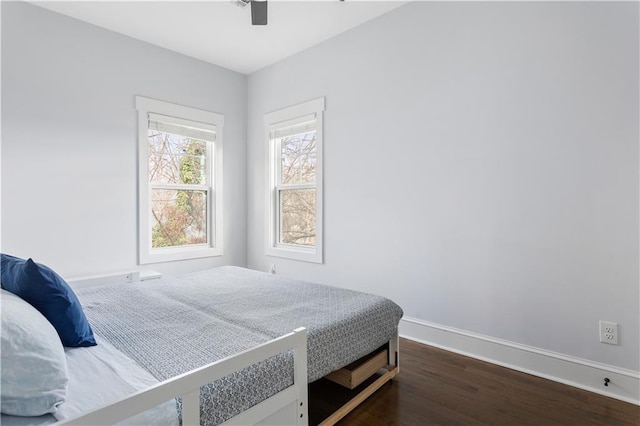 bedroom featuring baseboards, dark wood-type flooring, and a ceiling fan