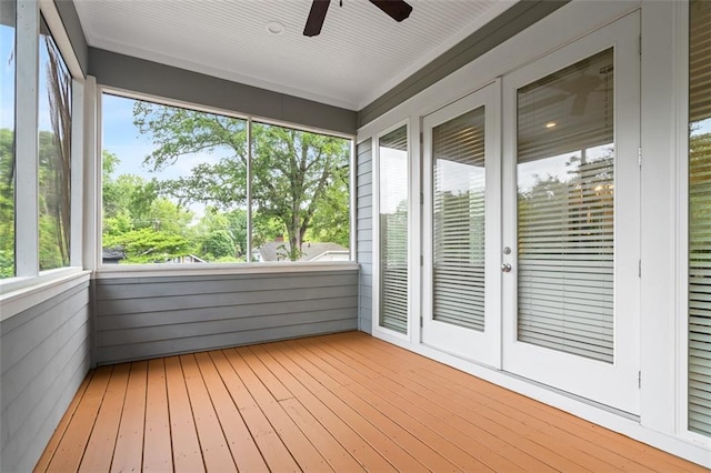 unfurnished sunroom featuring a ceiling fan and french doors