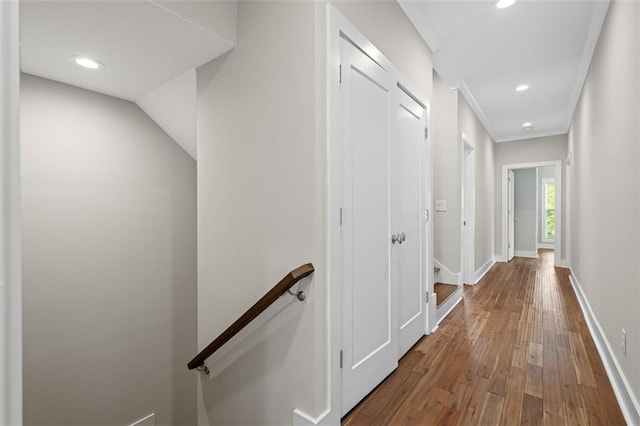 corridor featuring an upstairs landing, hardwood / wood-style flooring, recessed lighting, baseboards, and crown molding