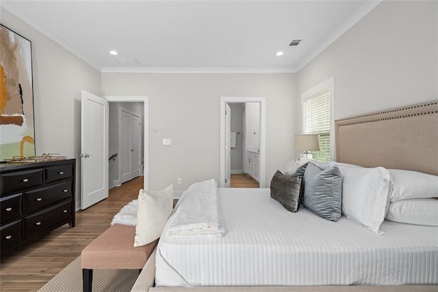 bedroom with ornamental molding, wood finished floors, ensuite bathroom, and recessed lighting