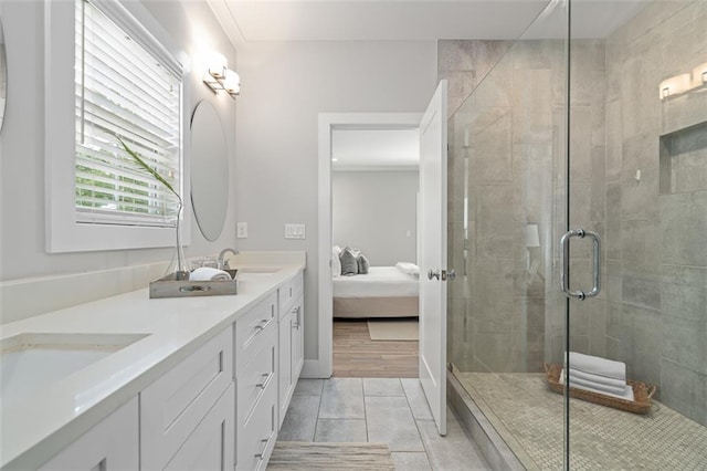 ensuite bathroom with a shower stall, double vanity, and tile patterned floors