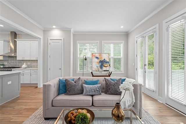 living area featuring light wood-style floors, plenty of natural light, ornamental molding, and recessed lighting