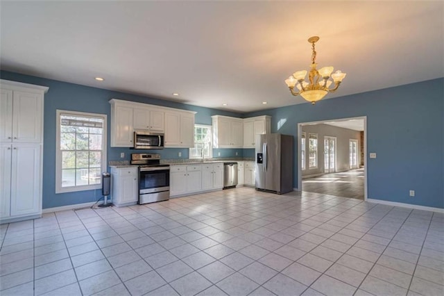 kitchen with white cabinets, decorative light fixtures, light tile patterned flooring, stainless steel appliances, and a chandelier