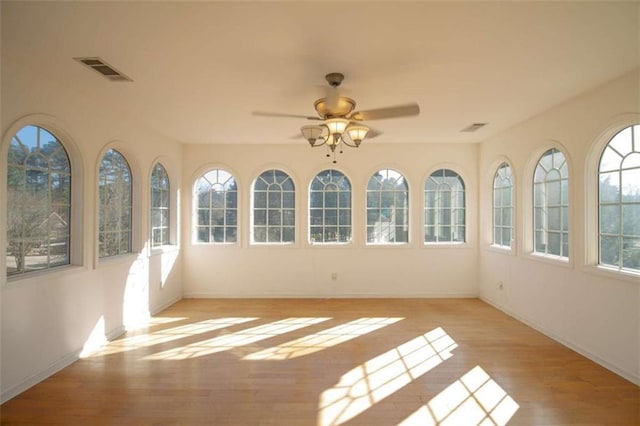 unfurnished sunroom with ceiling fan