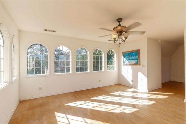 unfurnished sunroom with ceiling fan