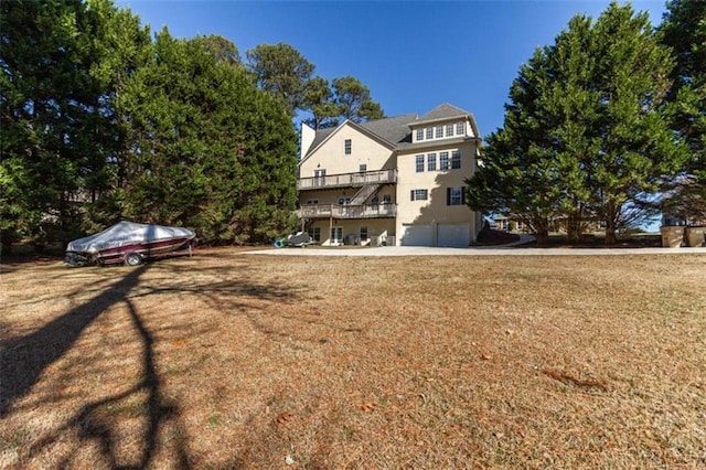 rear view of property featuring a lawn and a garage