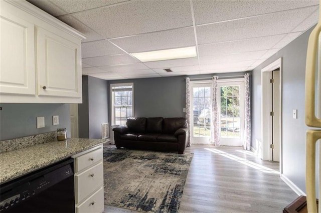 living room featuring a paneled ceiling and light hardwood / wood-style flooring