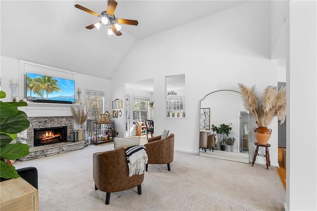 living room featuring light carpet, a stone fireplace, high vaulted ceiling, and ceiling fan