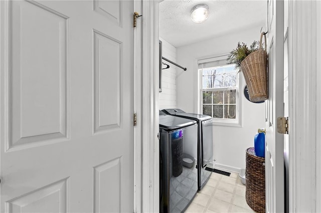 clothes washing area featuring washing machine and dryer and a textured ceiling