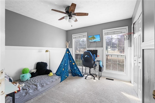 interior space featuring ceiling fan, carpet flooring, and a textured ceiling