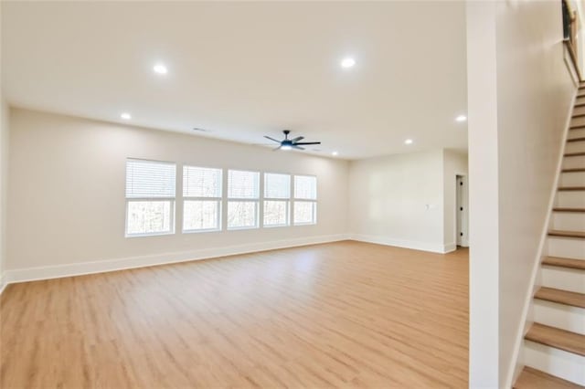 unfurnished living room with light wood finished floors, ceiling fan, stairway, and recessed lighting