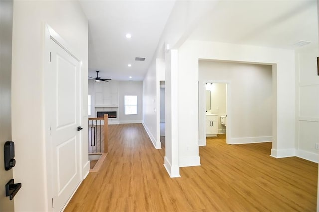 hall with recessed lighting, baseboards, visible vents, and light wood finished floors