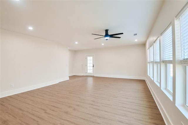 spare room featuring wood finished floors, a wealth of natural light, and baseboards