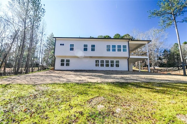 rear view of property featuring a yard and driveway