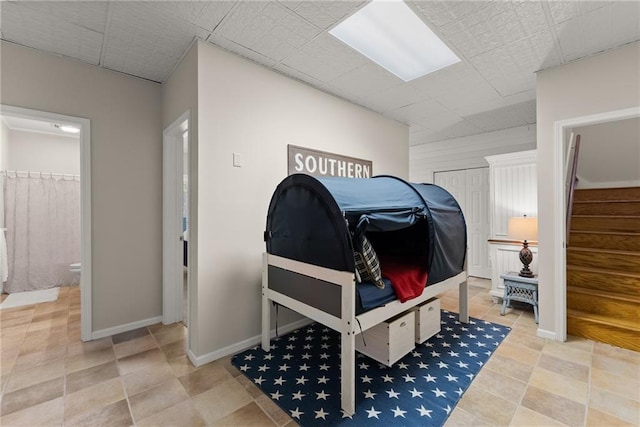 bedroom with ensuite bath and baseboards