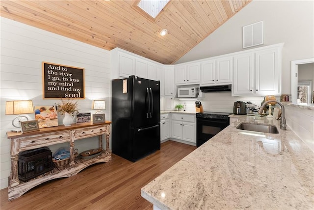 kitchen with under cabinet range hood, a sink, visible vents, light stone countertops, and black appliances