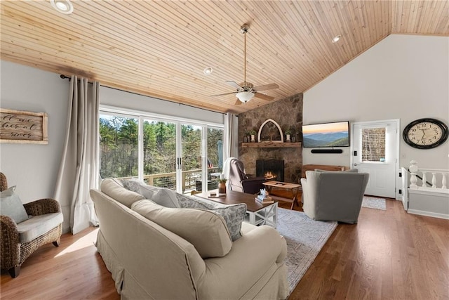 living area featuring high vaulted ceiling, a fireplace, ceiling fan, wood finished floors, and wood ceiling