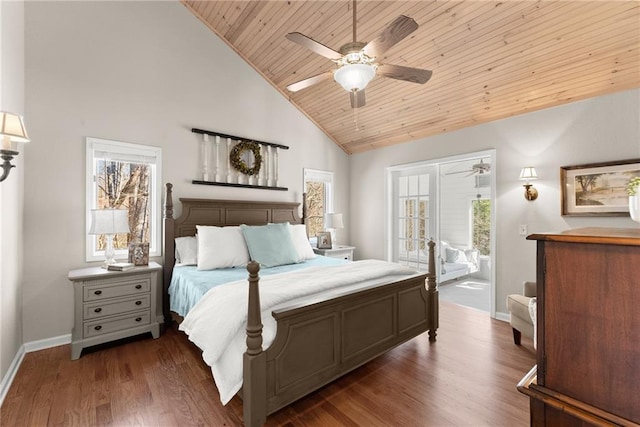 bedroom featuring baseboards, access to exterior, wood finished floors, and multiple windows