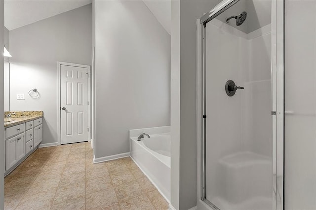 7165 Jonsway, Cumming, GA 30041 - bathroom featuring a shower stall, a garden tub, baseboards, vanity, and lofted ceiling